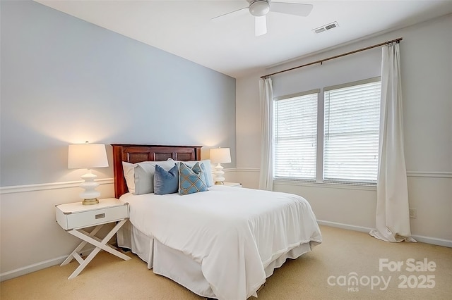 carpeted bedroom featuring a ceiling fan, visible vents, and baseboards