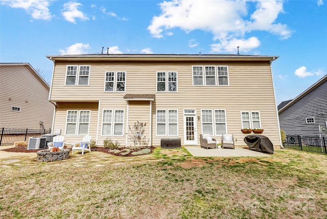 rear view of house featuring a patio area, an outdoor fire pit, a lawn, and a fenced backyard