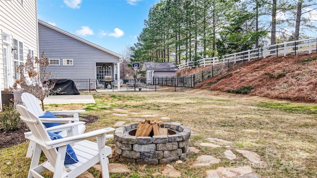 view of yard with a fire pit, a patio area, fence, and an outbuilding