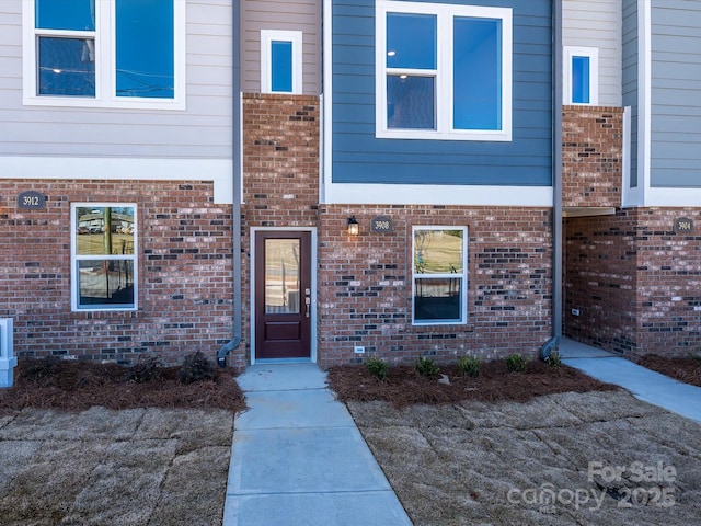 doorway to property featuring brick siding