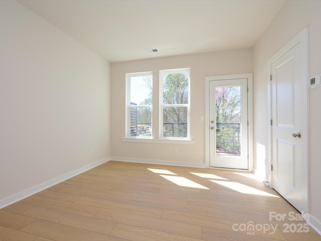 unfurnished room with light wood-style floors and baseboards