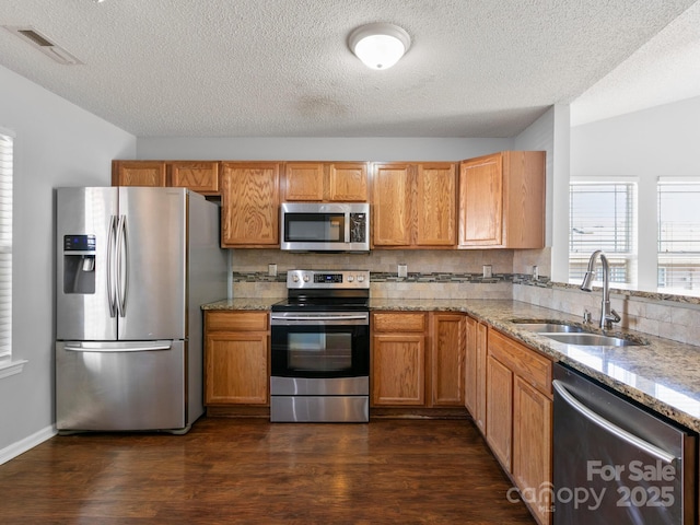 2302 Deermouse Way, Hendersonville, NC 28792 - kitchen featuring light stone counters, dark wood finished floors, stainless steel appliances, visible vents, and a sink