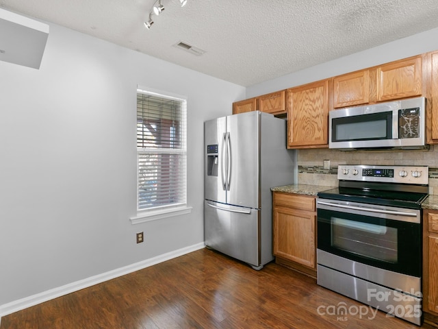 2302 Deermouse Way, Hendersonville, NC 28792 - kitchen featuring visible vents, light stone counters, appliances with stainless steel finishes, dark wood-type flooring, and backsplash