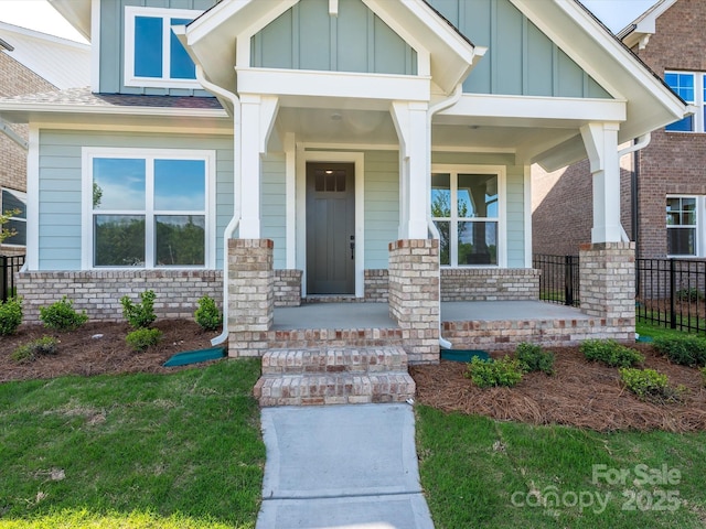 property entrance featuring board and batten siding and covered porch