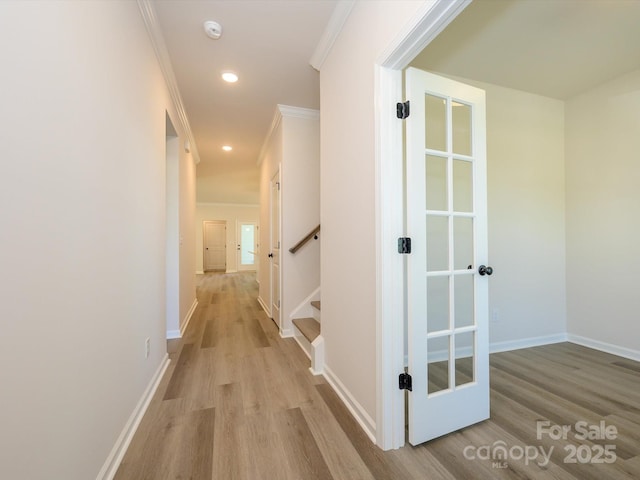 corridor with baseboards, crown molding, recessed lighting, light wood finished floors, and stairway