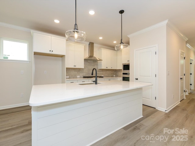 kitchen featuring wall chimney exhaust hood, crown molding, stainless steel oven, backsplash, and built in microwave