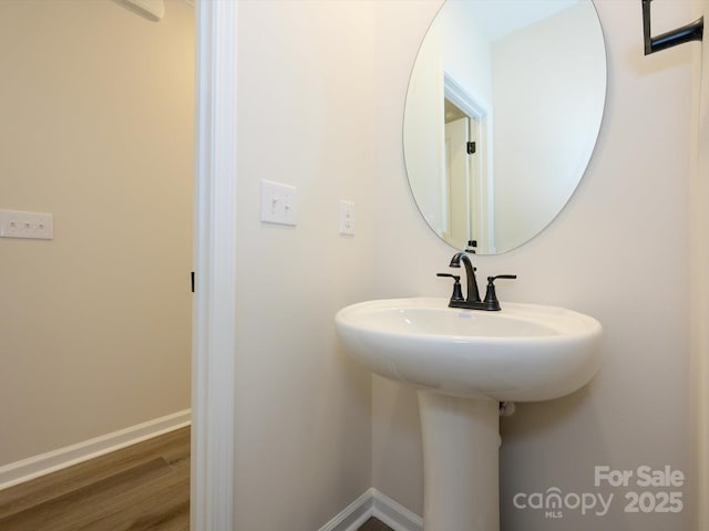 bathroom with wood finished floors and baseboards