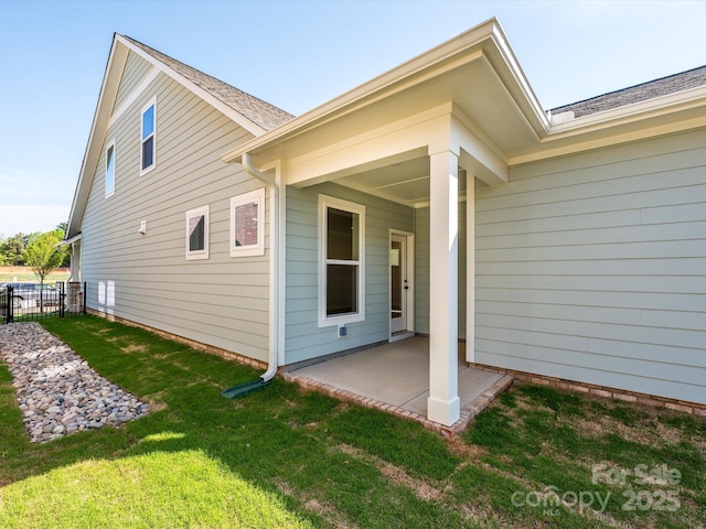 back of property featuring a patio area, fence, and a lawn