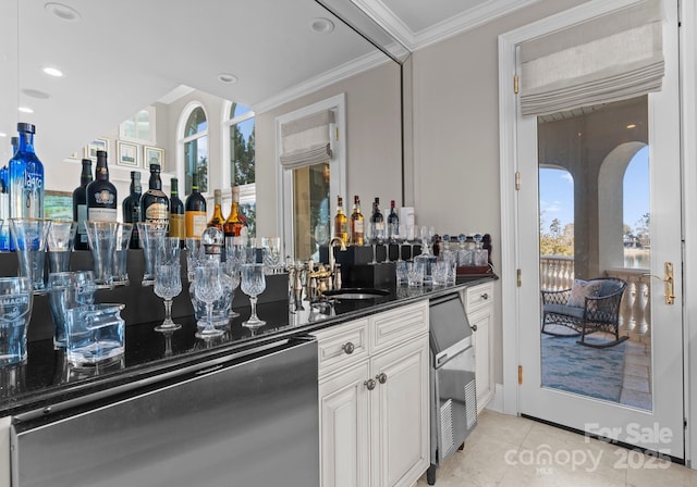 bar with light tile patterned flooring, a sink, ornamental molding, dishwasher, and indoor wet bar