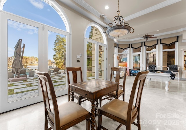 dining room with a towering ceiling, ceiling fan, a tray ceiling, crown molding, and recessed lighting