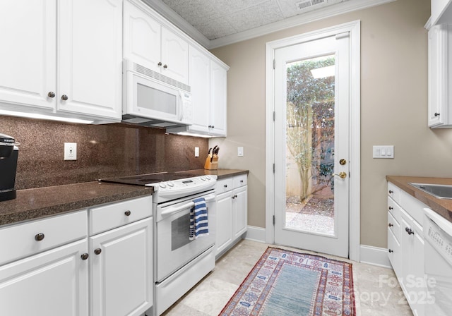 kitchen with white appliances, white cabinetry, baseboards, ornamental molding, and backsplash