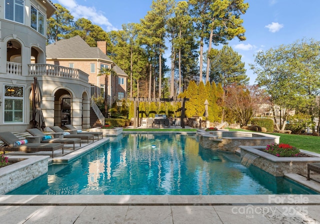 view of pool featuring a patio, a pool with connected hot tub, and a pergola