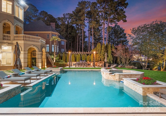 view of swimming pool featuring a patio area, a pool with connected hot tub, stairs, and a pergola