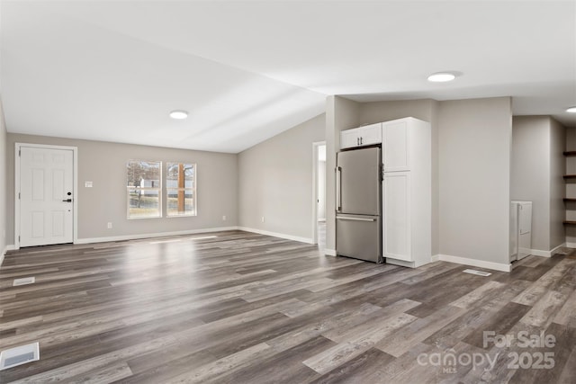 unfurnished living room featuring lofted ceiling, dark wood-style flooring, visible vents, and baseboards