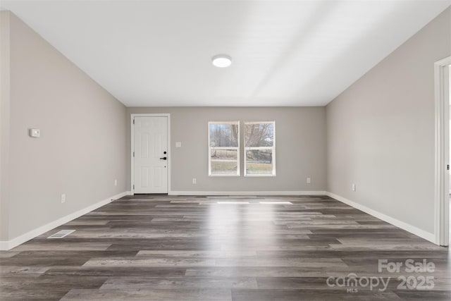 interior space with lofted ceiling, wood finished floors, and baseboards