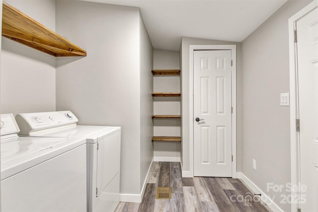 washroom featuring laundry area, baseboards, wood finished floors, and independent washer and dryer