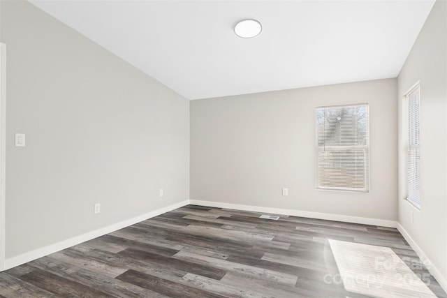 spare room with dark wood finished floors and baseboards