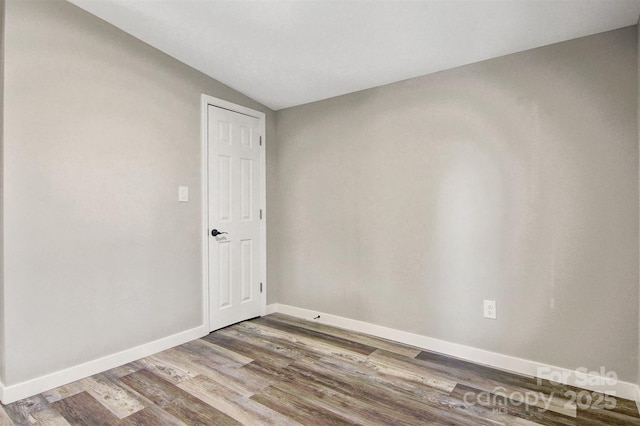 unfurnished room with lofted ceiling, baseboards, and wood finished floors