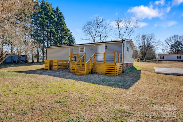 manufactured / mobile home with a front lawn and a wooden deck