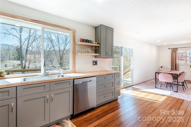 kitchen with gray cabinets, dishwasher, dark wood-type flooring, and sink