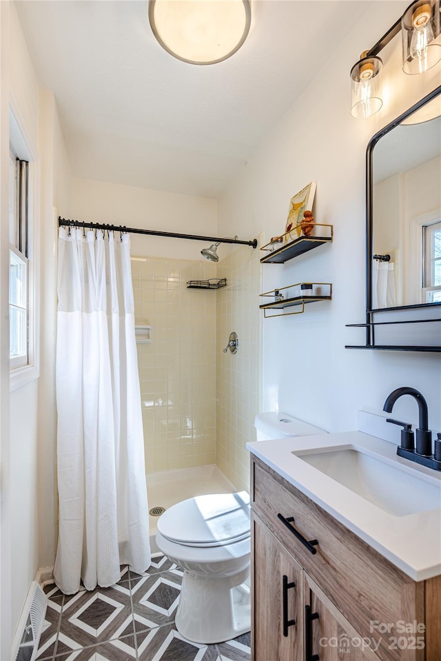 bathroom with toilet, vanity, and a shower with shower curtain