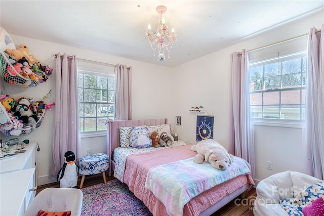 bedroom with hardwood / wood-style floors and a notable chandelier