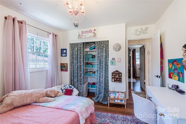 bedroom with dark hardwood / wood-style flooring and a chandelier