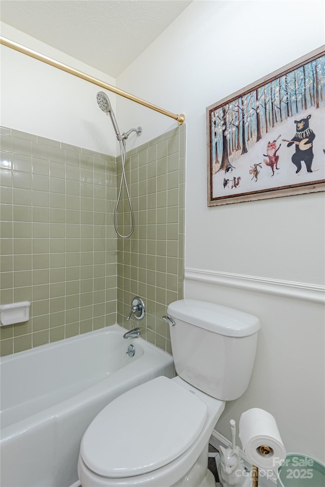 bathroom featuring toilet and tiled shower / bath combo