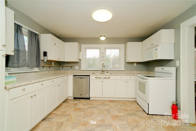 kitchen with a wealth of natural light, white appliances, light countertops, and a sink