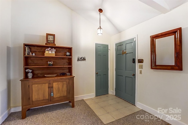 entryway with light tile patterned floors, baseboards, light carpet, and lofted ceiling