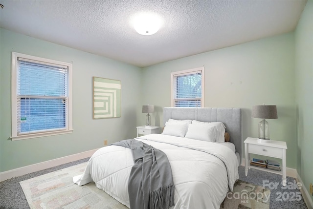 carpeted bedroom with baseboards and a textured ceiling