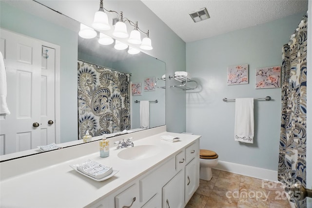 bathroom with visible vents, baseboards, toilet, vanity, and a textured ceiling