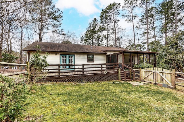 back of property featuring a deck, a gate, a yard, and fence