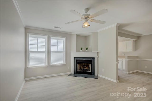 unfurnished living room with ornamental molding, light wood-style flooring, visible vents, and baseboards