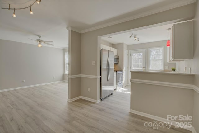 interior space featuring light wood-type flooring, a healthy amount of sunlight, appliances with stainless steel finishes, and light countertops