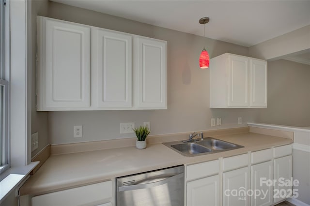 kitchen featuring light countertops, stainless steel dishwasher, a sink, and white cabinetry