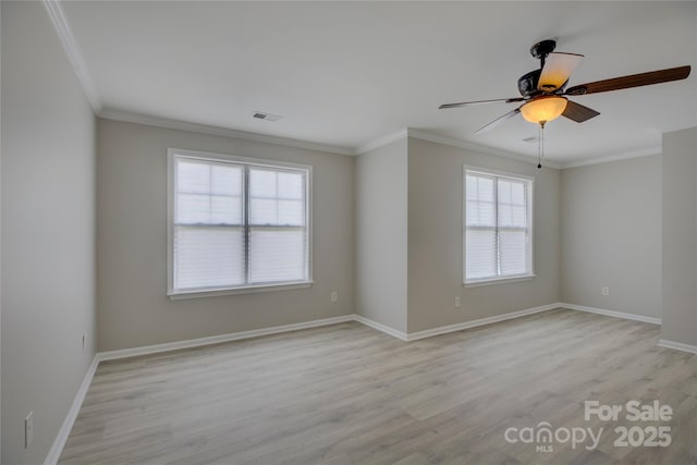 empty room with light wood-style floors, baseboards, visible vents, and ornamental molding