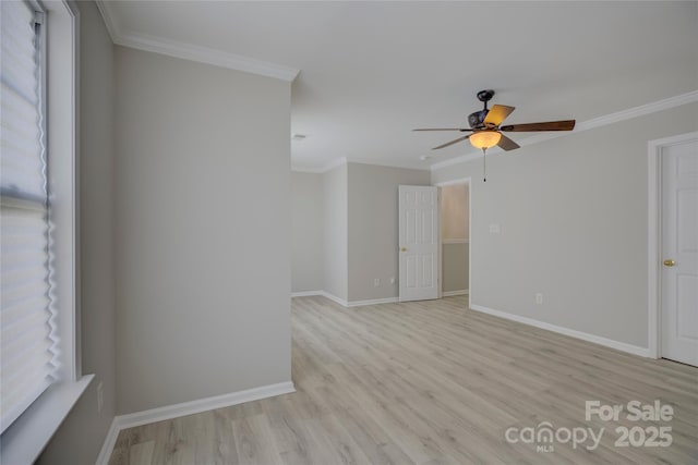 unfurnished room featuring baseboards, light wood-type flooring, and crown molding