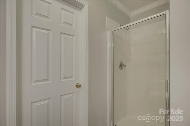 full bath with crown molding and a shower stall