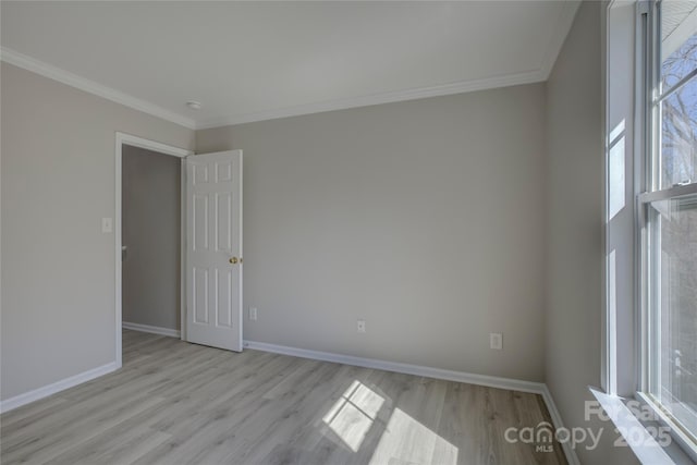 spare room with baseboards, light wood-style floors, and a healthy amount of sunlight