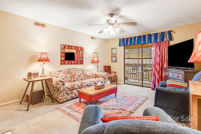 living room featuring carpet, ceiling fan, and a textured ceiling