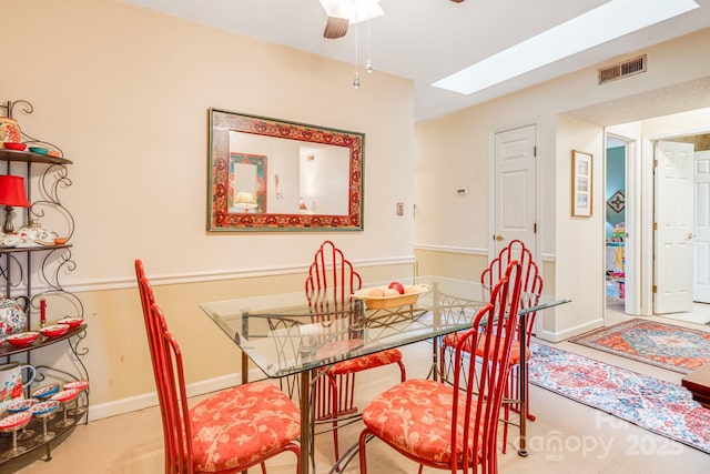 dining room with ceiling fan and a skylight