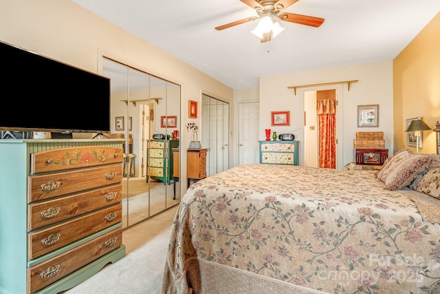 bedroom with light carpet, ceiling fan, and multiple closets