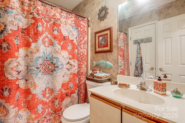 bathroom featuring a textured ceiling, toilet, and vanity