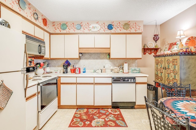 kitchen with white cabinetry, sink, backsplash, white appliances, and a textured ceiling