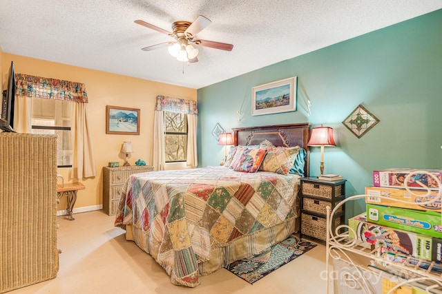 bedroom with ceiling fan, light carpet, and a textured ceiling