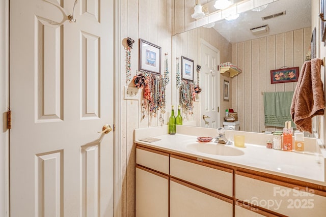 bathroom with vanity and wood walls