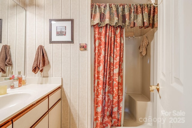 bathroom with vanity, wood walls, and curtained shower