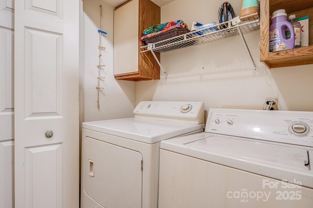 washroom with washer and dryer and cabinets