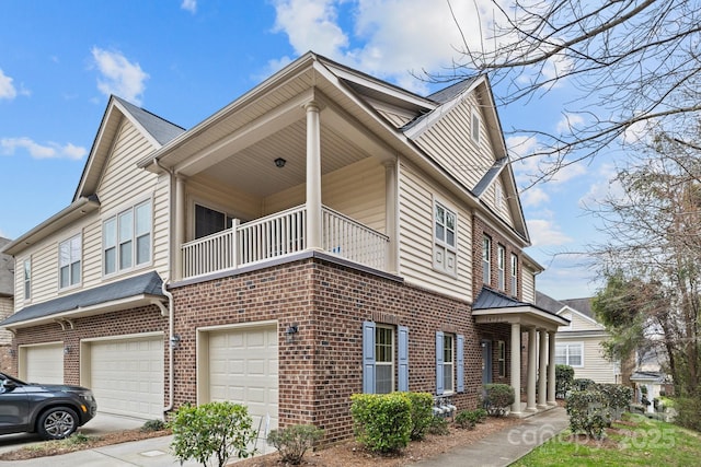 view of home's exterior with brick siding, a balcony, and an attached garage